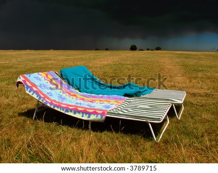 folding beds in a meadow against a storm background