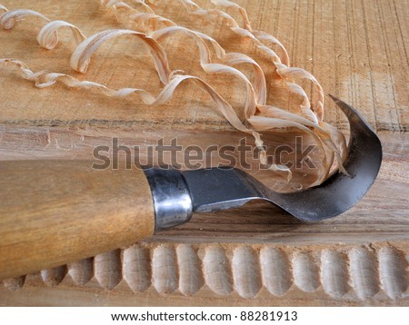 close-up of a carving knife and wood shavings