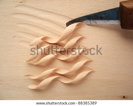 closeup of knife blade and wood shavings