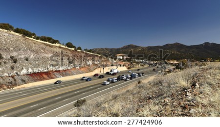Prescott, Arizona, USA, March 5, 2015 Cars stopped at traffic light traveling on Highway 69 in Prescott, Arizona with mountains in background