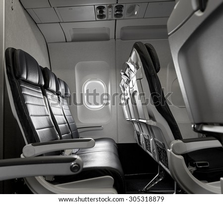 Row of empty airline seats with light shining in window