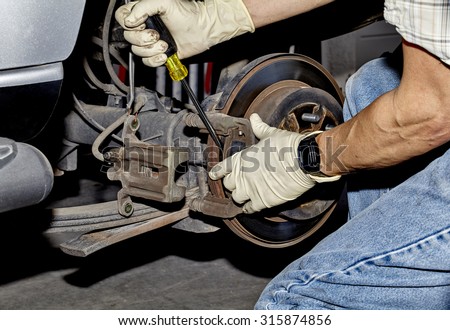 Mechanic changing brake pads on a car