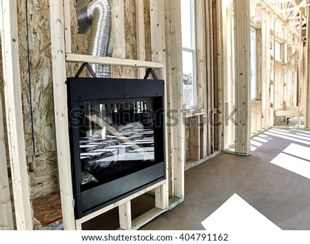 Framed home showing installation of a gas fireplace with vent