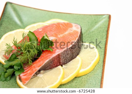 salmon with lemon and parsley on plate isolated on white background