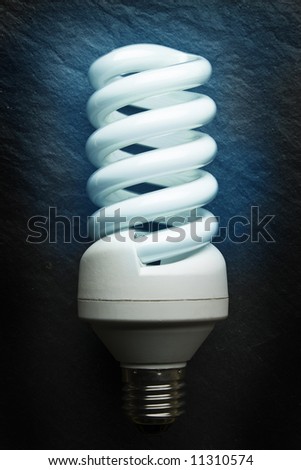 Fluorescent light bulb on a grey background.