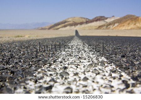 Black asphalt road in California, United States. Shallow depth of field on the foreground.