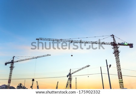 Tower cranes sillouetted against a sunset sky, Sunset cranes
