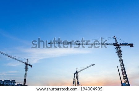 Tower cranes sillouetted against a sunset sky, Sunset cranes