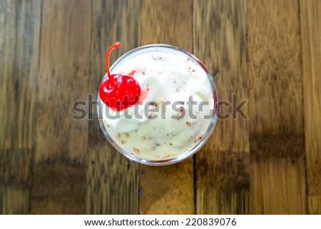Delicious vanilla ice cream sundae topped with cherry