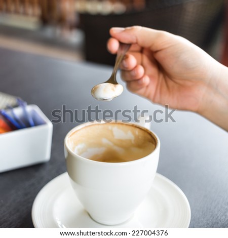 foam inside the coffee spoon against the cup on the table
