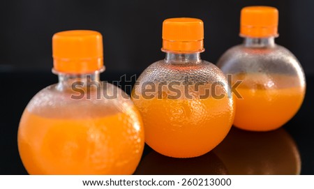 Fresh orange drink over black background