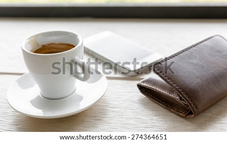Espresso, coffee cup on table and mobile phone,wallet
