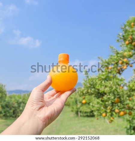 The orange juice in the plastic bottle, orange juice bottle in hand