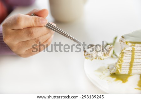 woman hands taking greentea crepe cake piece with spoon, Select focus on a cake in spoon