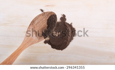 Heap of powdered black pepper on a wooden spoon, shallow depth of field, milled black pepper