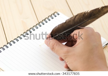 Hand writing a notebook with a feather pen, Hand writting with feather