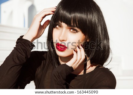 Vogue Style Woman with red lipstick and black short hair. glossy smooth fashion hair. Beautiful brunette girl with bright makeup.Hairstyle. isolated on white background. Red lips, red nails. Sexy look