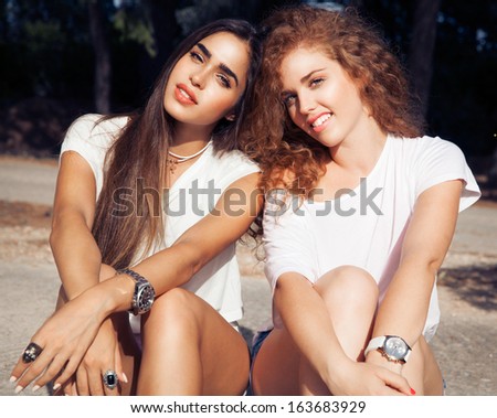 Couple of two beautiful smiling girls in fashion style. Women with long hair.  Beautiful best friends in white  style   make  girls. outdoors shot, horizontal. - Stock Image - Everypixel