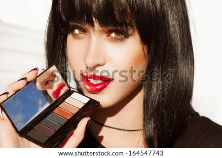 portrait of Pure beautiful woman with red lipstick and bright make up. Woman with black hair , hairstyle . Red Lipstick . Palette of shadows .Pretty girl ,fashion style. Sexy look.Horizontal shot.