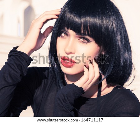 Woman with short stylish hairstyle and pink make up.Exotic woman beauty. Black shine hair . Hairdresser. Female . Retro style . Sexy look . Pink lips.