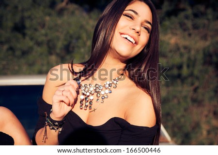 Smiling woman beauty. Woman with bright make up and necklace. Shine healthy skin.Fashion portrait . Long shine hair. Sexy look. Outdoors shot. Soft colors