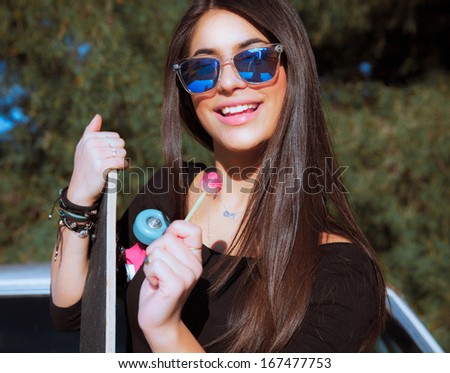 Young smiling woman with a lollipop. Cute female . Smiling style . Portrait with a sunglasses .Outdoors shot. Horizontal