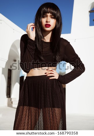 Woman with long black hair and black outfits.