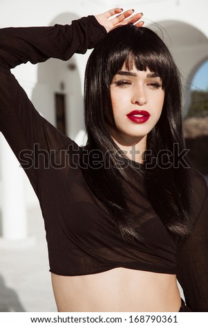 Woman with long black hair and black outfits.
