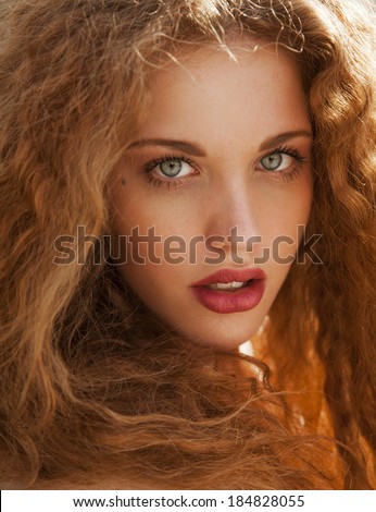 Beauty portrait of beautiful blonde girl with long hair and bright make up in studio. vertical shot. summer colors