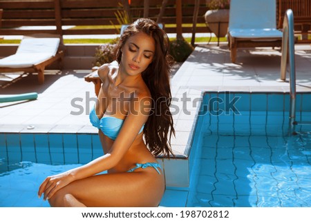 Summer beauty. Beautiful long hair female  posing by the pool.  Resting by the pool. Toned in warm colors.  outdoor portrait. horizontal shot