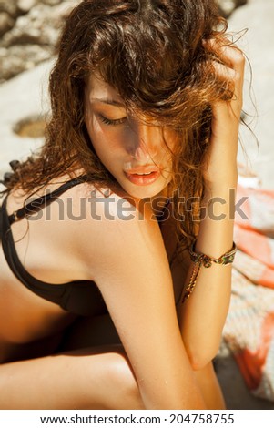 Summer beauty. Beautiful long hair female posing by the sea. Toned in warm colors. outdoor portrait. Horizontal shot.