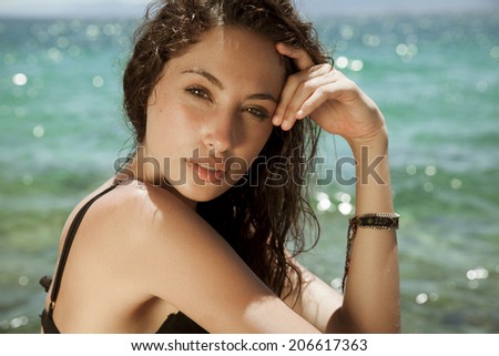 Carefree beautiful brunette with wet look and long hair on the beach. Natural woman beauty. Toned in warm colors. Copy space for your text. horizontal shot, outdoors