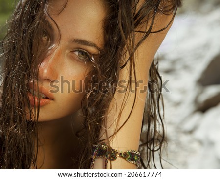 Close up of pure woman beauty with wet hair and bright skin. Toned in warm colors. horizontal shot on the beach.