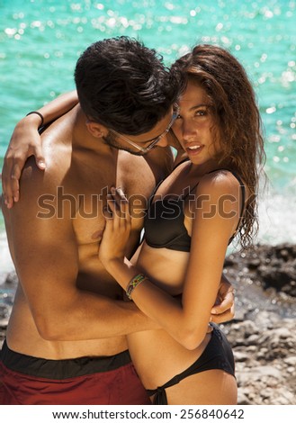 Sexy young passionate couple in bikini. Summer style. Toned in warm colors. Vertical shot