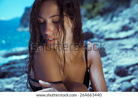 Carefree beautiful brunette with wet look & long hair on the beach. Natural woman beauty. Toned in warm colors. Copy space for your text. horizontal shot, outdoors