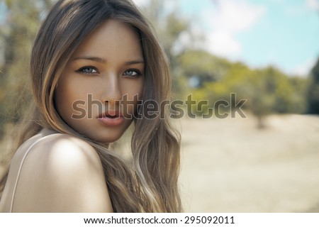 Portrait of a beautiful woman face with bright makeup and blonde hair .Autumn portrait style. Toned in warm colors. Copy Space for your text horizontal shot.