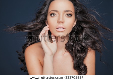 Beautiful model with wavy hairstyle.Portrait of young woman with makeup and clean skin. Toned in warm colors. Studio shot, horizontal