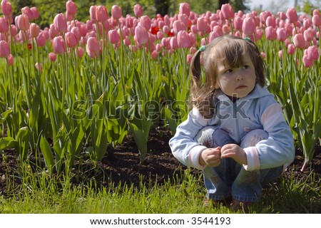 Dreaming beautiful little girl in pink tulips