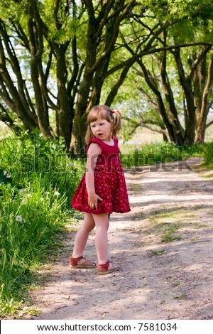 Little girl walking through the woods looking for something turning back
