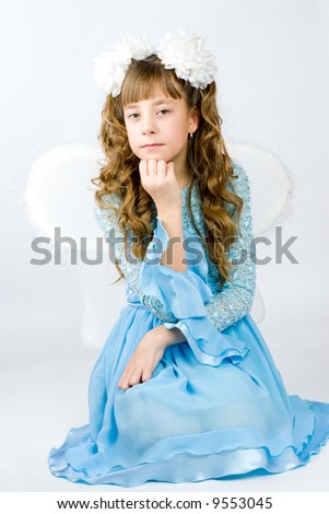 Girl wearing wings beautiful blue dress and white bows for a holiday