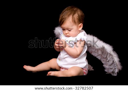 stock photo six month baby angel over black background