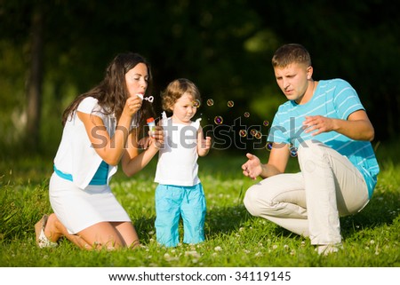 Happy Family making soap bubbles outdoors summer