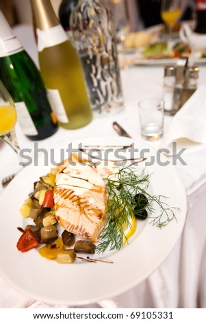 Salmon fish dish decorated on white plate in restaurant