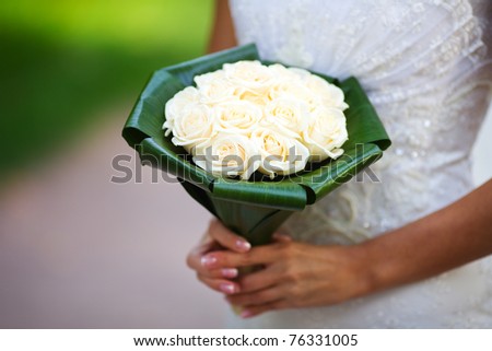 Bride holding roses vivid flowers bouquet in hands