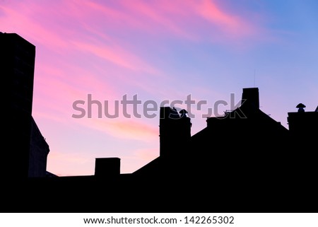 silhouette of the roof with a blue and pink sky at dusk in a city