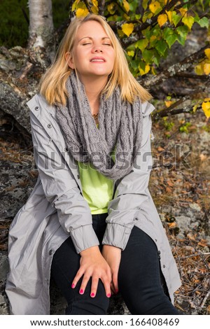 woman enjoying life sitting on a rock in the woods