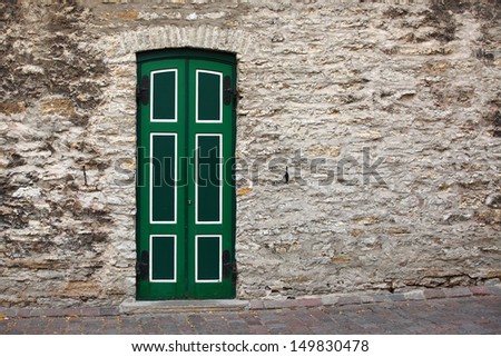 Green door and rock wall