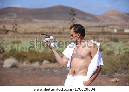 Man in white trousers in aloe field with bone head