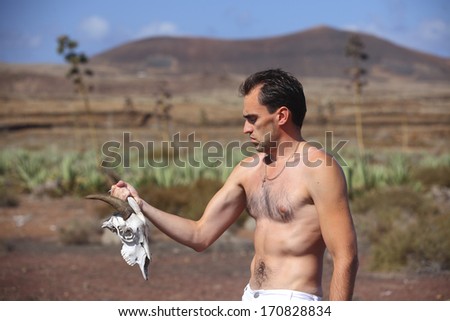 Man in white trousers in aloe field with bone head