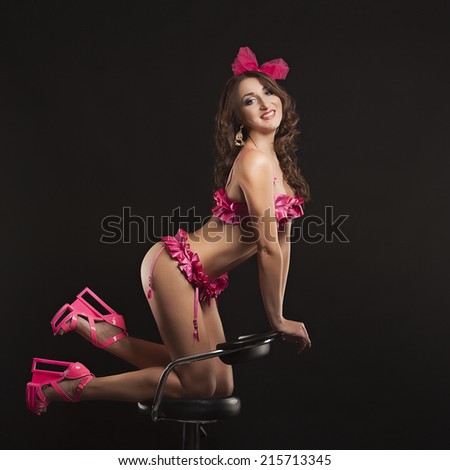 Burlesque dancer in pink dress, isolated on black